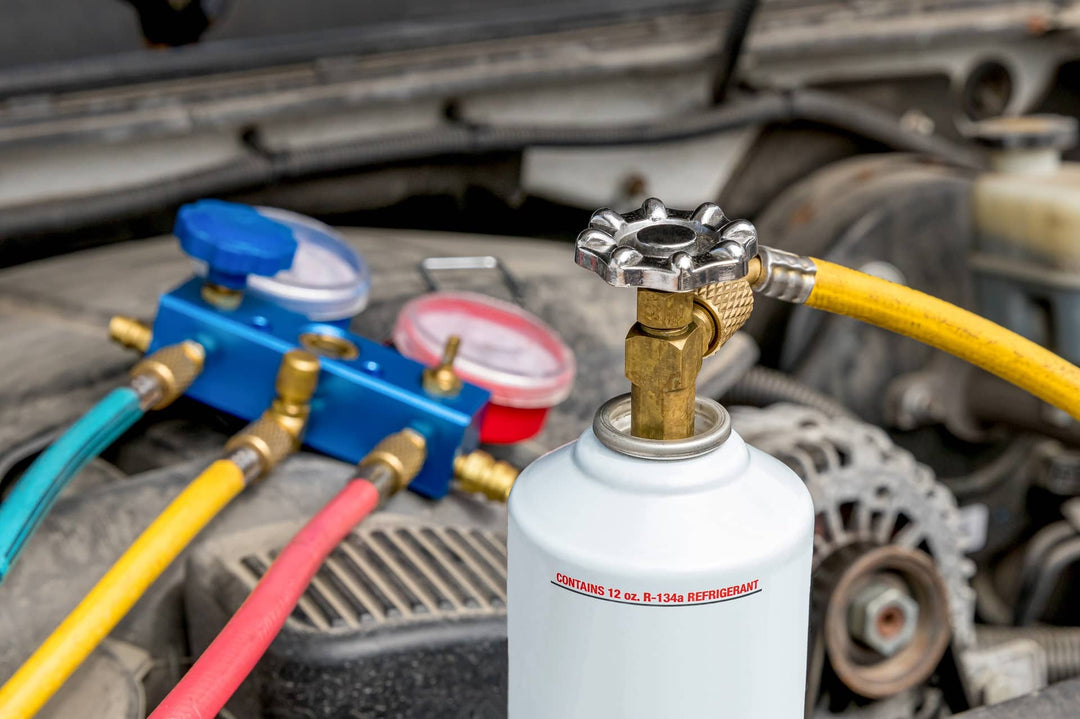 A mechanic inspecting a vehicle’s air conditioning system for refrigerant compatibility.