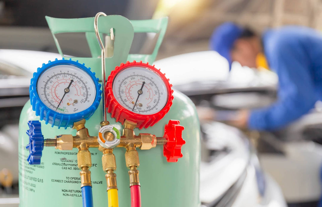 A professional HVAC technician recharging a car’s air conditioning system with refrigerant.