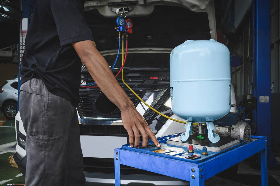 A mechanic inspecting a car’s air conditioning system with R134a refrigerant.